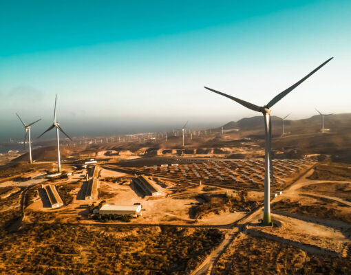 Panoramic view of wind turbine and solar panels in background - Panoramic view of wind turbine and solar panels in background - Sustainable environment concept